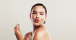 © KayExam/peopleimages.com - Lip gloss, kiss and makeup with portrait of woman in studio for beauty product, self care and cosmetics. Tools, aesthetic and salon with person on white background for shine, treatment and glamour