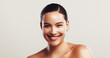 © KayExam/peopleimages.com - Studio, woman and portrait with glow for skincare, treatment and confidence by mockup space. Happy, female person and model with smooth face for beauty, dermatology and wellness by white background