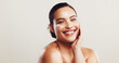 © KayExam/peopleimages.com - Smile, woman and lotion with skincare in studio of facial hydration, repair skin and treatment benefits. Happy, person and cream product with dermatology glow, anti aging results and white background