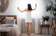 © Prostock-studio - Slim asian woman wrapped in towel looking through the window in bedroom after waking up in the morning, copy space. Full size photo of unrecognizable lady looking through the window, home interior