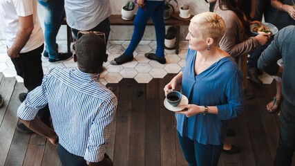 Wall Mural - people socializing at casual gathering, holding drinks. a diverse group mingling, chatting, and enjo
