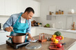© Pixel-Shot - Young man with recipe cooking soup in kitchen
