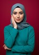 © AlfaSmart - Portrait of a confident woman in teal hijab on a red background