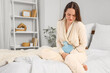 © Pixel-Shot - Young woman suffering from menstrual cramps  in bedroom