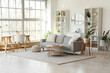 © Pixel-Shot - Interior of light living room with grey sofa, workplace and mirror