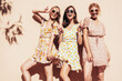 © halayalex - Three young beautiful smiling hipster female in trendy summer dress clothes. Sexy carefree women posing in the street. Positive models having fun outdoors at sunny day. Cheerful and happy. Near wall