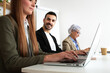 © Daniel - Happy young businessman looking at camera in the office. Colleagues working with laptop.