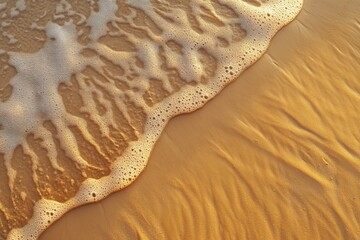 Aufkleber - Gentle waves create foam on the warm sandy beach at sunrise, inviting a calm start to the day