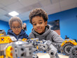 © Gesfera Images - Two young boys concentrating on building robots in a stem education class, promoting innovation and learning