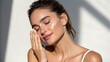 © VisionCrafter - A young woman with flawless skin gently applies a creamy moisturizer to her face, enjoying a luxurious skincare routine in soft, natural light highlighting her radiant complexion.