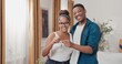 © ABCreative - A married couple stands in their new apartment at the start of their journey together, smiling with excitement as they hold the keys to their newly purchased or rented home in their hands.