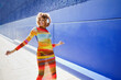 © VISTA by Westend61 - Woman with curly afro hairstyle walking outdoors listening to music