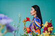 © VISTA by Westend61 - Woman in colorful clothing holding flowers in a vibrant spring setting
