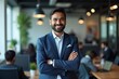 © Vera - Confident Indian businessman posing with crossed arms in a modern IT company office