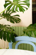 © Krystsina - interior of cafe work place with live green plants, blue chair and white table