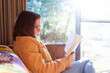 © Austockphoto - Winter light coming through window on teen girl reading a book