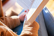 © Austockphoto - Teen girl reading a novel in the lounge room by a window in winter