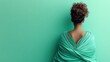 © milenialdesastudio - Woman in teal draped gown, back view against a mint green background