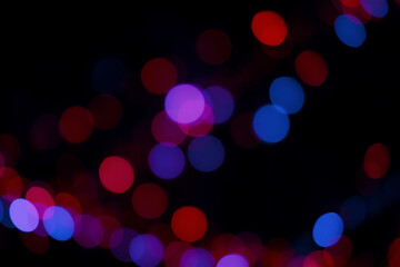 Aufkleber - Softly blurred lights in red, purple, and blue hues create a beautiful bokeh effect against a stark black background, evoking a sense of gentle illumination and abstract beauty.