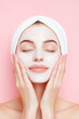 © zetrum - Woman with a facial mask and a towel on her head, eyes closed, resting hands on cheeks. Serene