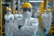 © Ilya - Industrial safety protocols in action: team of workers in protective gear on factory floor