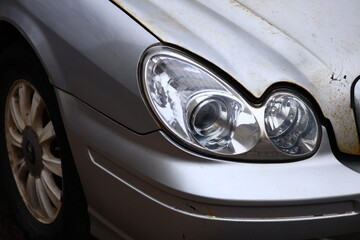 Wall Mural - a white car with a rusted headlight, suitable for use in scenarios where mechanical failure is a key