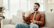 © peopleimages.com - Fist pump, support and television with man on sofa in home living room for subscription service. Celebration, streaming and watching tv with sports fan cheering or celebrating success in apartment