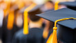 © Curioso.Photography - A graduate in a cap and gown with a yellow tassel, standing in a sea of fellow graduates, celebrating their academic achievement during a graduation ceremony.