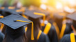 © Curioso.Photography - A close-up of graduation caps with yellow tassels, with a blurred crowd of graduates in the background during a graduation ceremony.