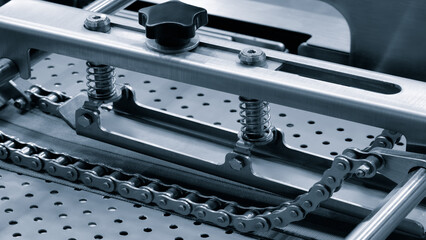 Poster - A metal chain is attached to a machine. The chain is made of metal and is connected to a machine, industrial concept background