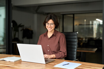 smiling hispanic businesswoman company employee sitting at work desk, professional female hr manager