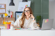 © Pixel-Shot - Female web designer working at table in office