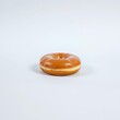 © dadtophoto - A single glazed donut sits on a pristine white background, sugary, glossy