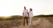 © peopleimages.com - Farm, walking and holding hands with senior couple, love and relationship with vacation for honeymoon. People, outdoor or dirt road with old man, mature woman and countryside with romance or marriage