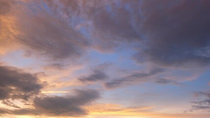 Wall Mural - A breathtaking timelapse of the sky at dawn, where the clouds dance across the sky, bathed in the warm light of the rising sun.
