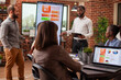 © DC Studio - Bearded businessmen stand near digital screen, presenting marketing strategies at group meeting. Black male entrepreneur with clipboard leads business project presentation at brick wall office.
