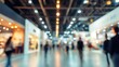 © yang - Blurred background of international business exhibition and conference, professionals walking and communicating among booths, wide angle shot with bokeh effect and warm lighting.