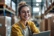© nian - Candid laugh. Smiling joyful young girl wholesale warehouse worker postal delivery service sales manager cargo transportation company employee having fun at workplace desk looking on notebook screen