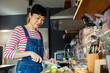 © Marko Geber - Close up of woman cutting vegetables in modern kitchen
