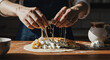 © SlavaOkey - Hands skillfully prepare a delicious dish with melted cheese