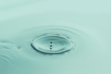 Wall Mural - teal water droplet impact, creating concentric ripples.