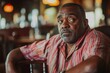 © Hanna Haradzetska - 50-year-old Black man with a slightly unfocused expression, visibly tipsy, leaning back in a wooden chair in a rustic pub setting