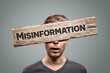 © photoschmidt - Misinformation sign in front of a person's face