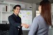 © Natee Meepian - Networking and Professional Relations. A business associate exchanging a handshake in a modern office.