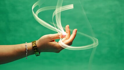 Wall Mural - motion and grace: a graceful hand with elegant gestures, dances with flowing streaks of light agains