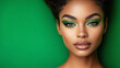 © Oleksandr - A close-up of a woman with striking green eye makeup and flawless skin, set against a green backdrop.