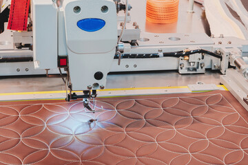 Poster - A sewing machine is in use, stitching a pattern onto a piece of fabric