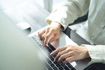Wall Mural - close up of business woman hands typing on laptop computer and digital tablet, searching and surfing