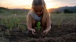© PT CINTA SEJATI - Young girl planting a seedling outdoors at sunset