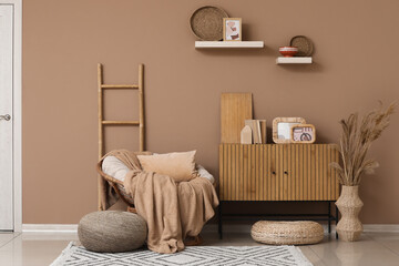 Wall Mural - Interior of living room with wicker armchair, ladder and home decor on commode